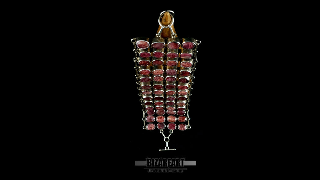 Vertical view of articulated sterling silver collar necklace showing 13 segmented rows set with natural raw ruby cabochons.