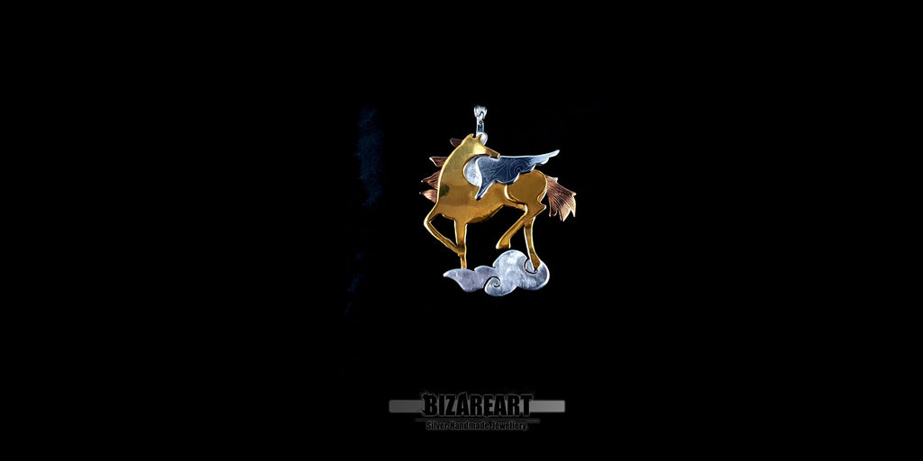 Wide-angle view of the tri-tone Pegasus jewelry piece displayed on a red velvet pillow, showcasing the artisan metal layering technique.