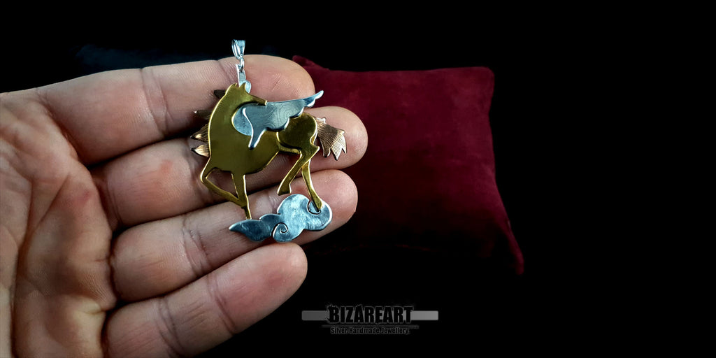 Lifestyle scale shot of the Pegasus pendant held in a hand to demonstrate its 5cm size and substantial artisan craftsmanship.