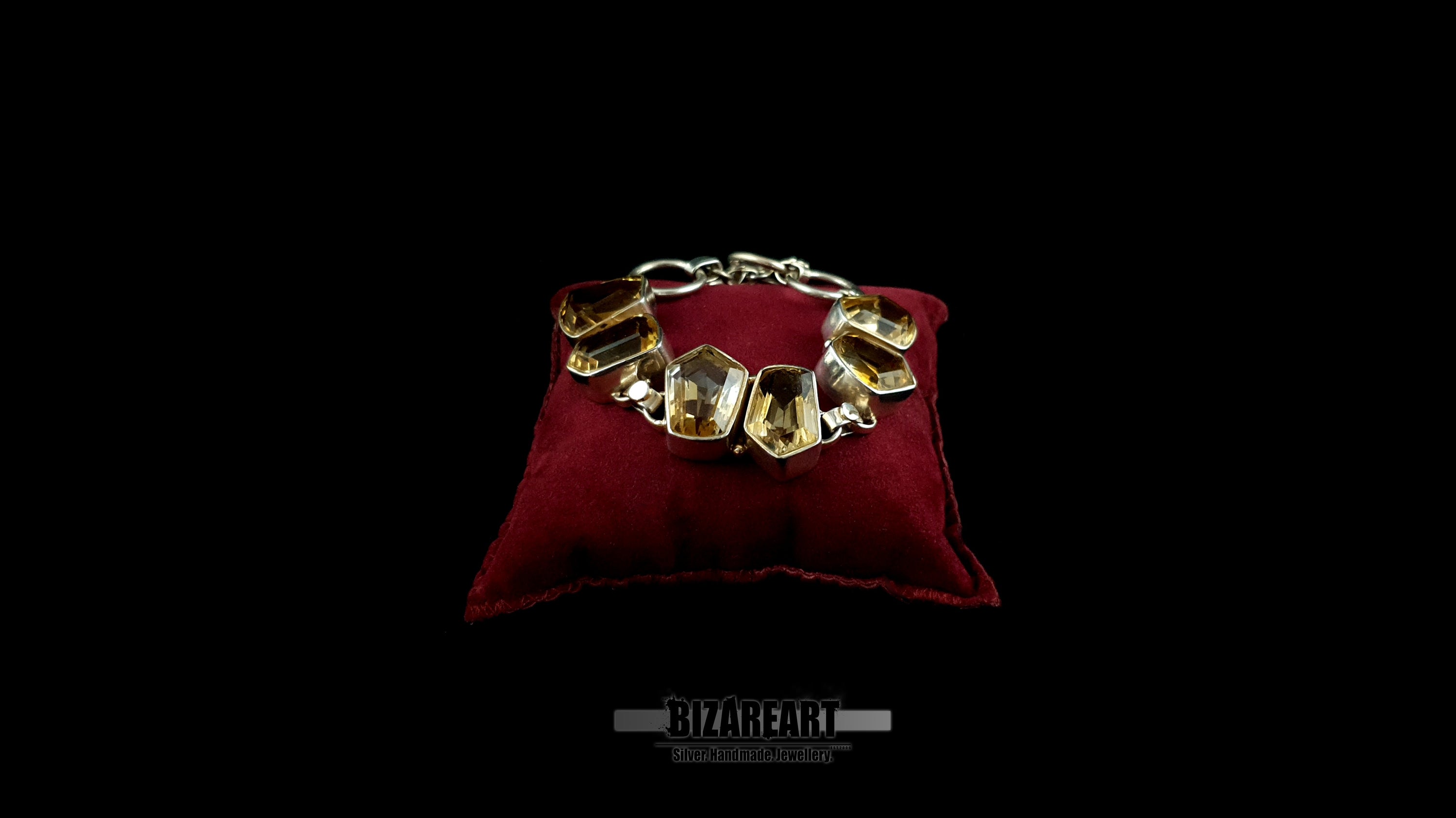 Handcrafted 925 sterling silver citrine bracelet looped on a luxury red velvet display pad
