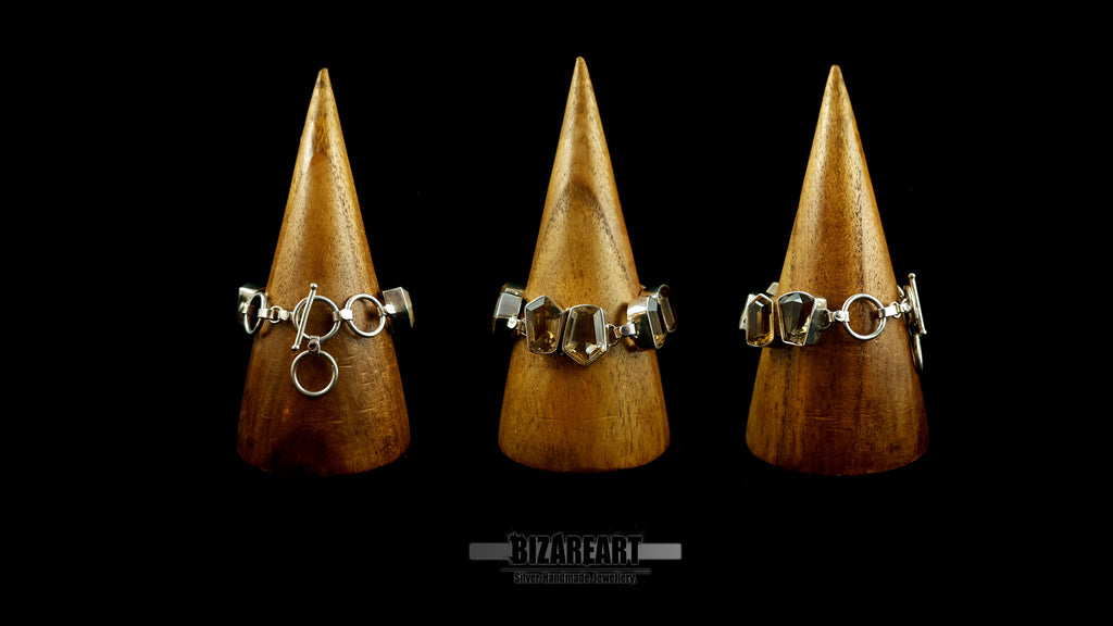 Group display showing the architectural sterling silver citrine bracelet on wooden cone stands