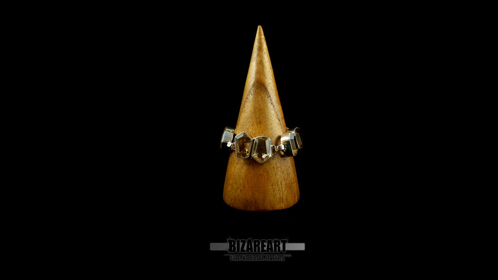 Close-up view of hand-finished bezel settings and citrine gemstones on wooden cone