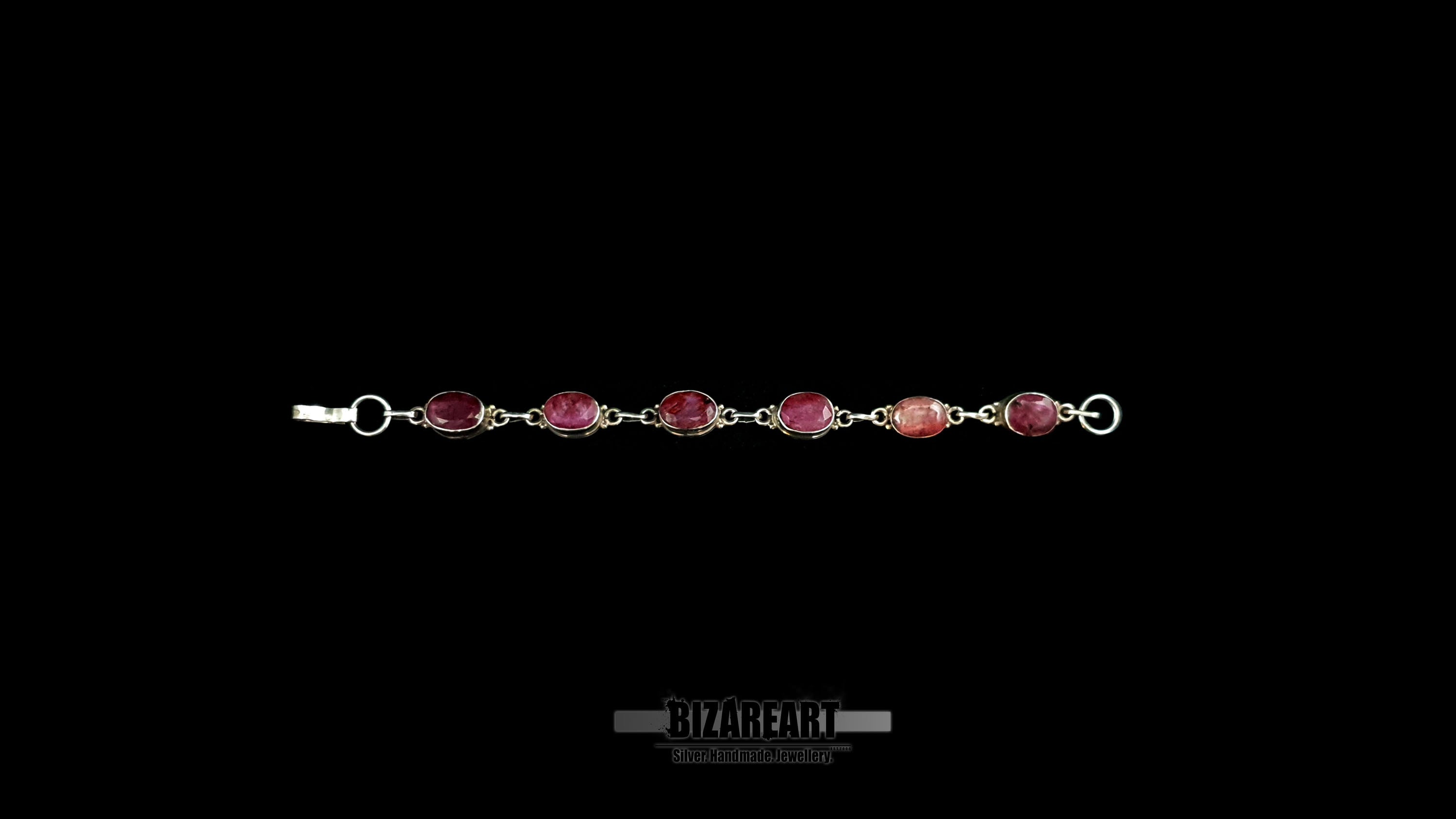 Full-length view of a 20cm handmade sterling silver chain bracelet featuring six evenly spaced raw ruby bezel settings.