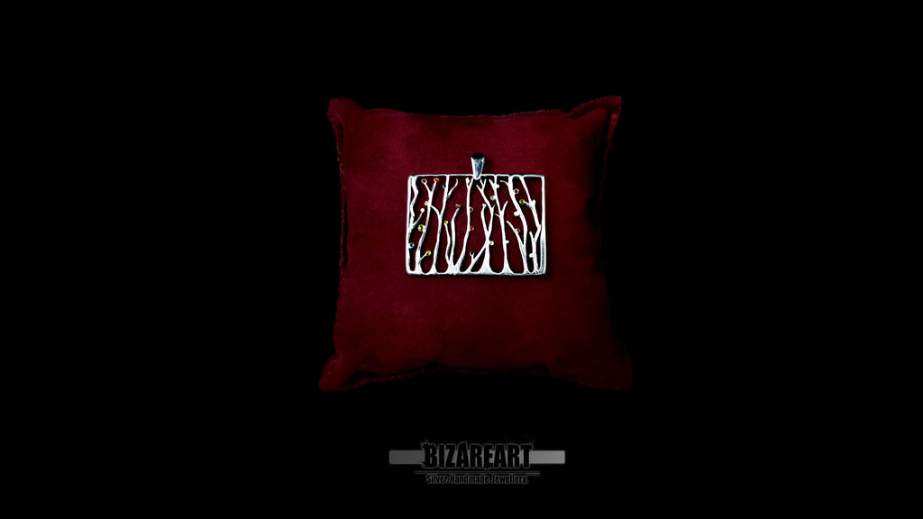 Silver Seaweed rectangular pendant necklace in solid 925 sterling silver, displayed horizontally on a luxury dark red velvet pillow against a black background.
