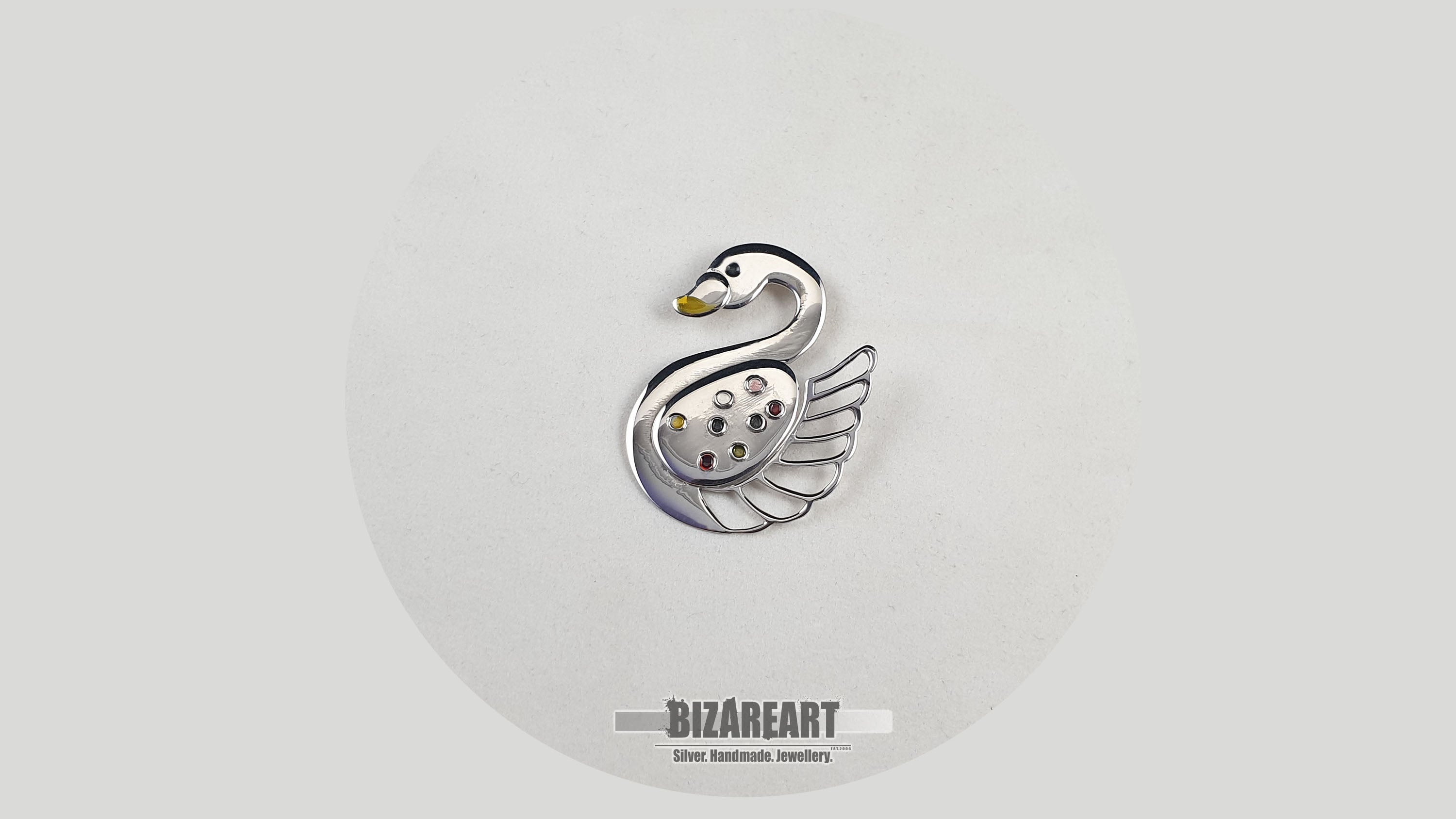 High-resolution top view of the artisan swan jewelry showing intricate layered silver sheets and vibrant liquid enamel details.
