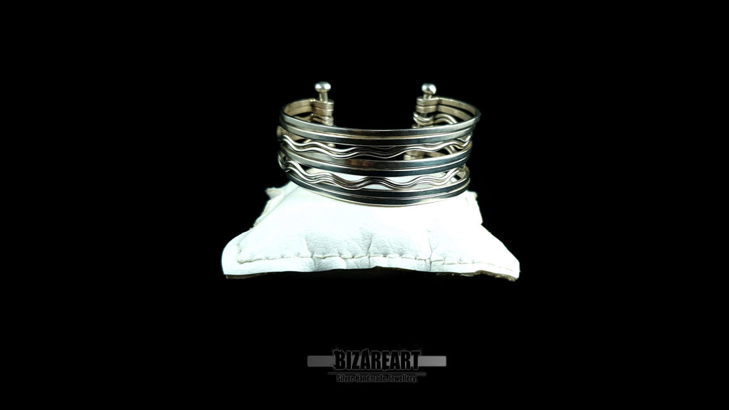 Front view of 58.7g artisan multi-strand silver cuff showcasing the vertical ball terminal anchor bars on a white leather jewelry cushion.