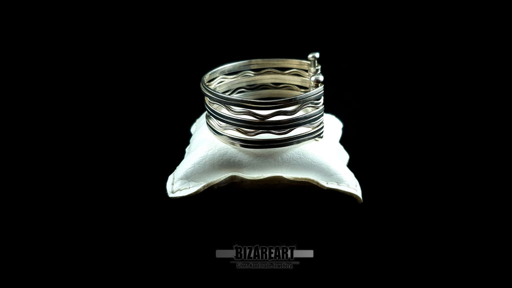 Side view of 58.7g artisan multi-strand silver cuff showcasing the vertical ball terminal anchor bars on a white jewelry cushion.