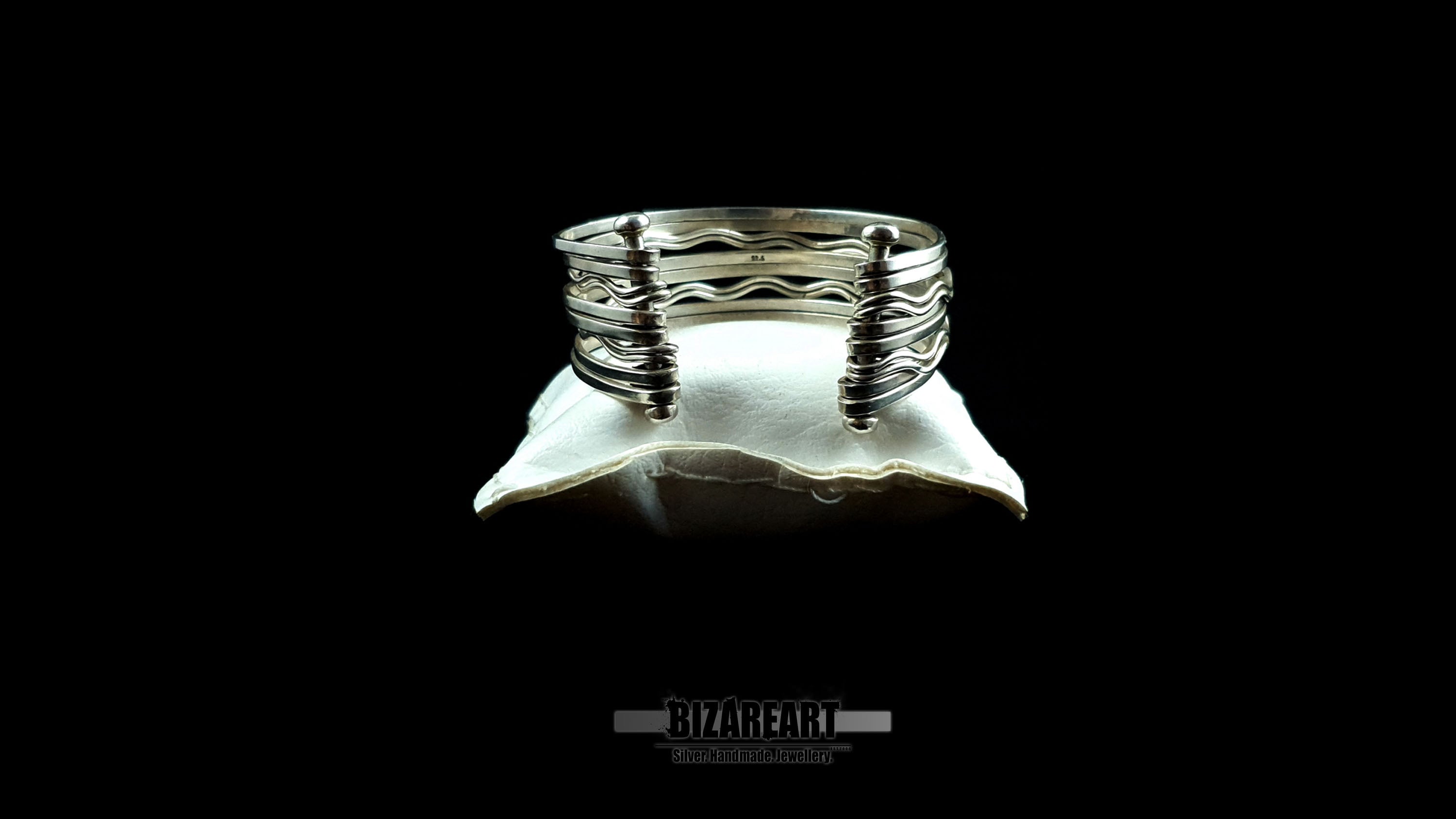 Back side view of 58.7g artisan multi-strand silver cuff showcasing the vertical ball terminal anchor bars on a white leather jewelry cushion.