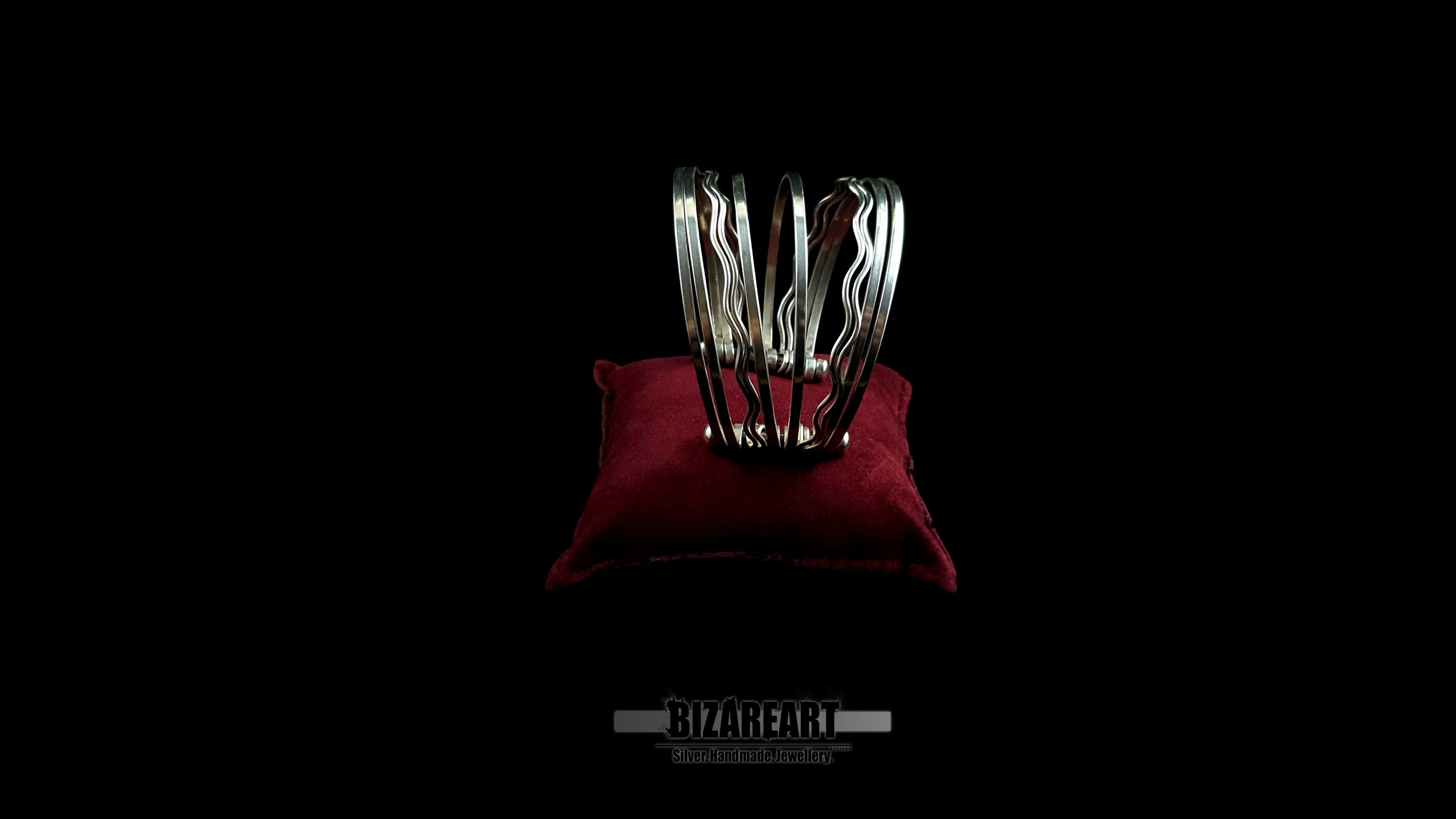 Side view of 58.7g artisan multi-strand silver cuff showcasing the vertical ball terminal anchor bars on a red leather jewelry cushion.