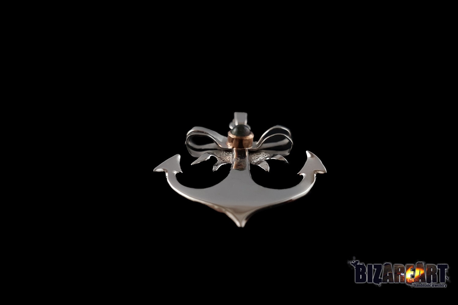 A bottom-up perspective emphasizing the thickness of the silver arms and the intricate detail where the rose-plated bow meets the anchor stock.