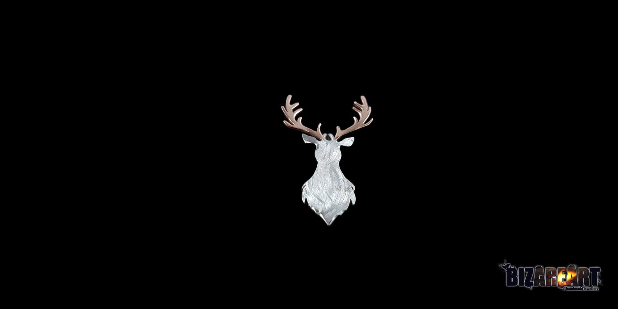 A front-facing studio shot of a handcrafted deer head pendant against a solid black background. The pendant features a textured white-silver body with intricate, branching rose gold antlers.