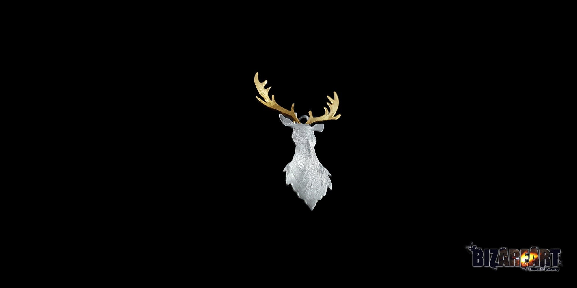 Three-quarter view of the deer pendant, illustrating the depth of the carved lines and the organic, layered silver textures.