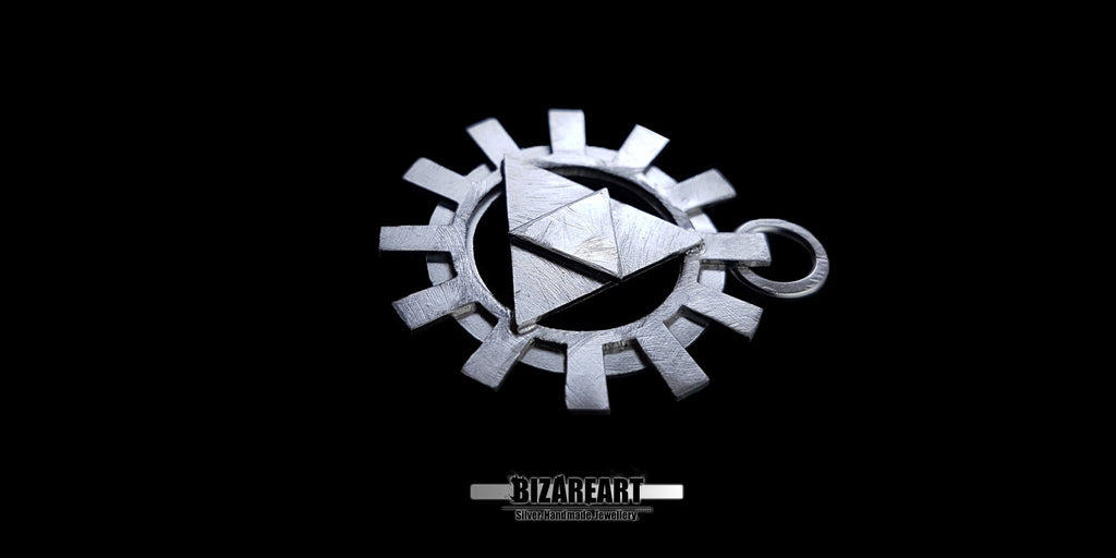 An angled close-up shot of the silver Zelda Triforce cog pendant, highlighting the thick, multi-layered construction and metallic shine against a black backdrop.