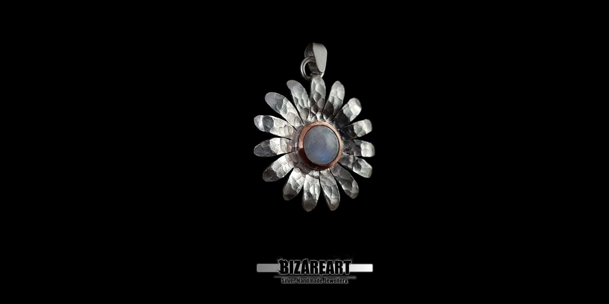 Studio shot of the artisanal mixed-metal daisy pendant, showcasing the contrast between the hammered silver petals and the warm copper accent around the gemstone.