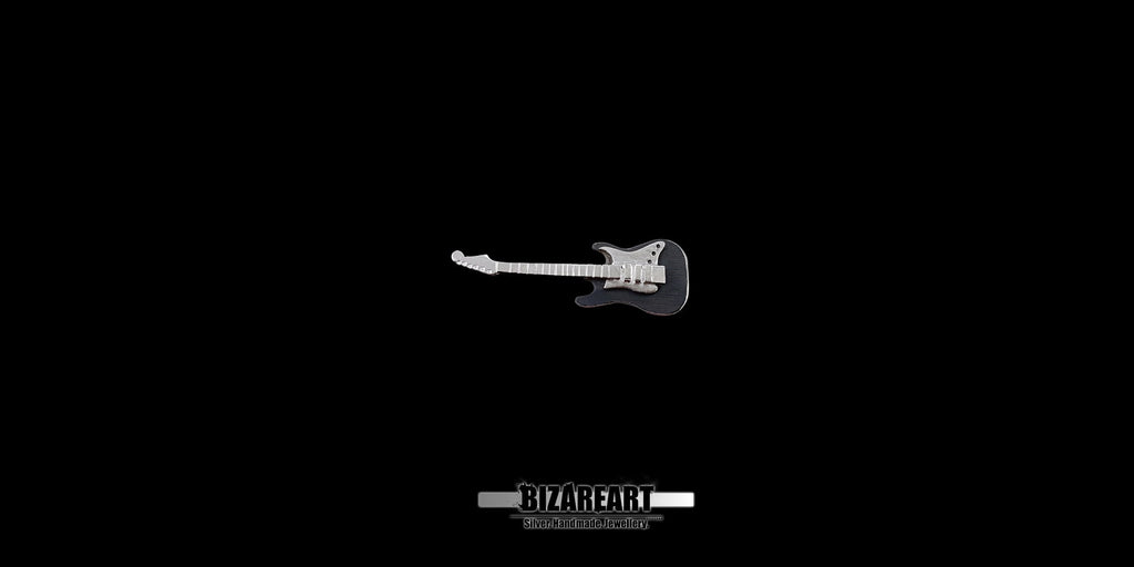 Side profile of the sterling silver guitar pendant, demonstrating the multiple layers of metal and the textured, three-dimensional construction of the piece.