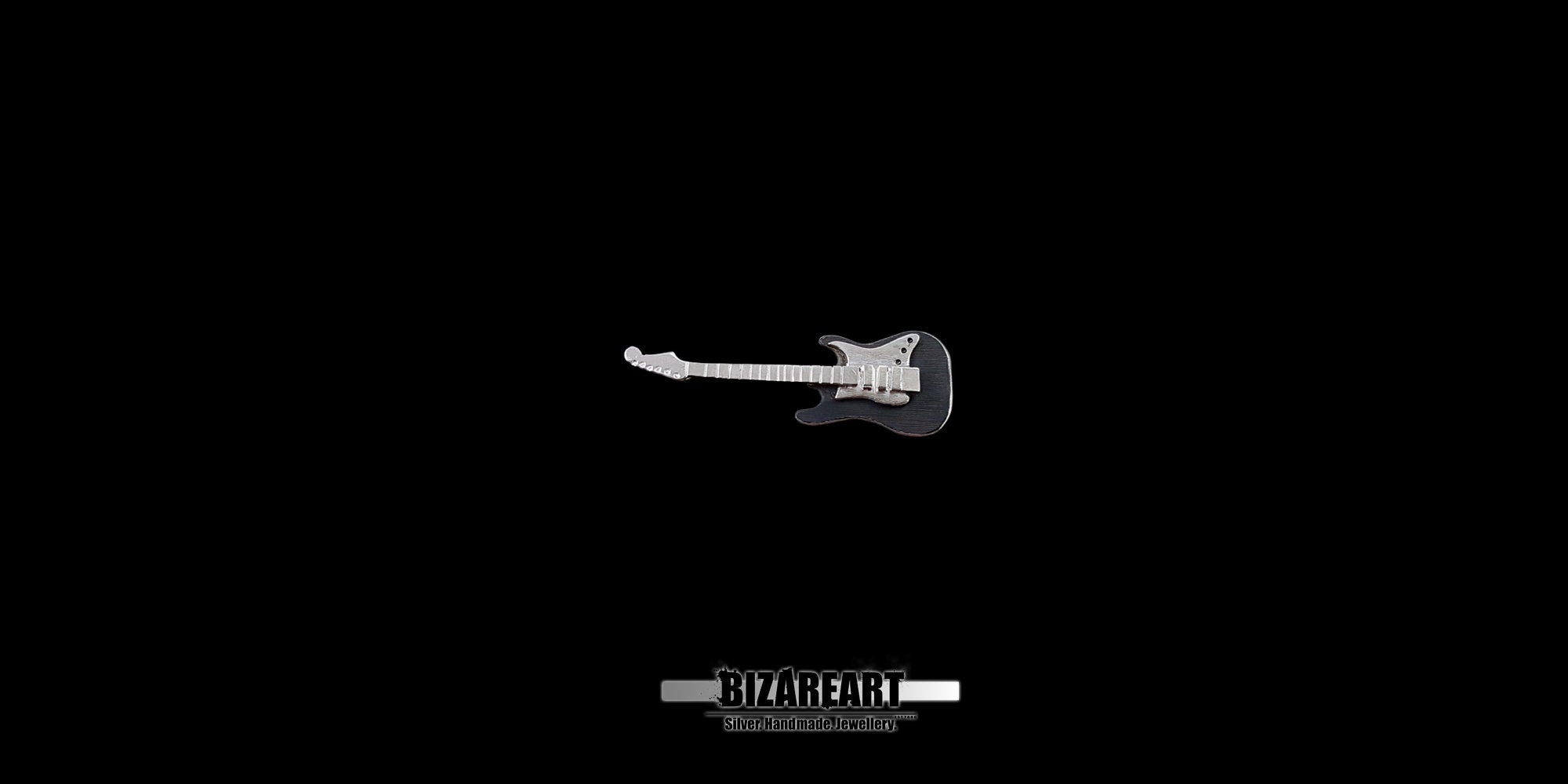 Side profile of the sterling silver guitar pendant, demonstrating the multiple layers of metal and the textured, three-dimensional construction of the piece.