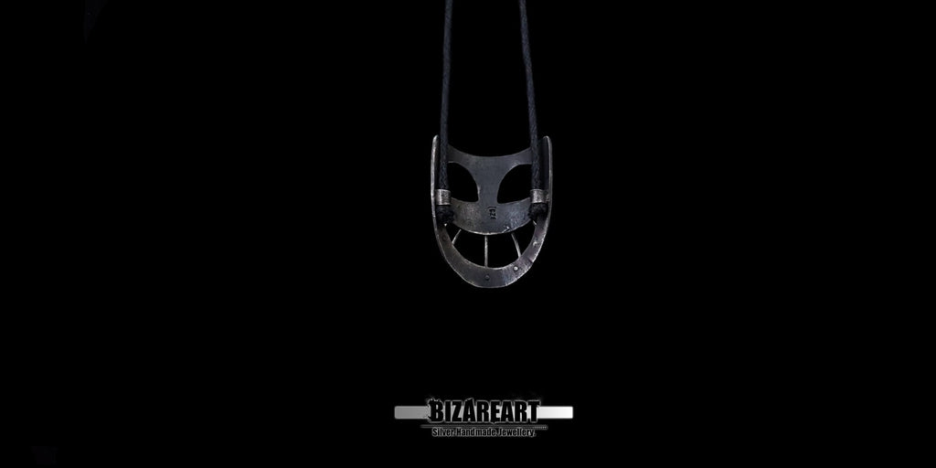 Inside Straight-on view of the detailed look at the gothic-inspired oxidized silver mask jewelry piece.