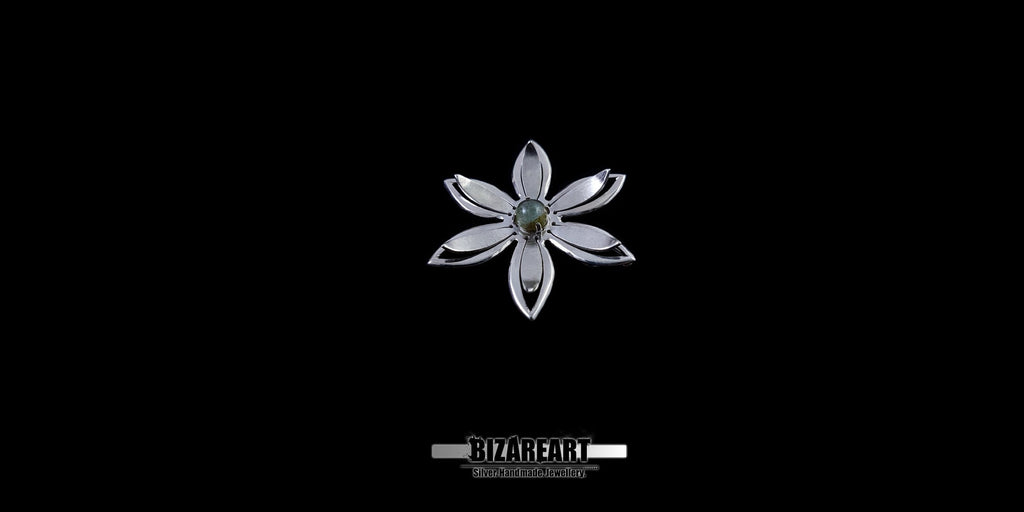 A series of product photography shots showing the silver flower pendant from various angles on a black background, highlighting the metallic sheen and the depth of the central gemstone.