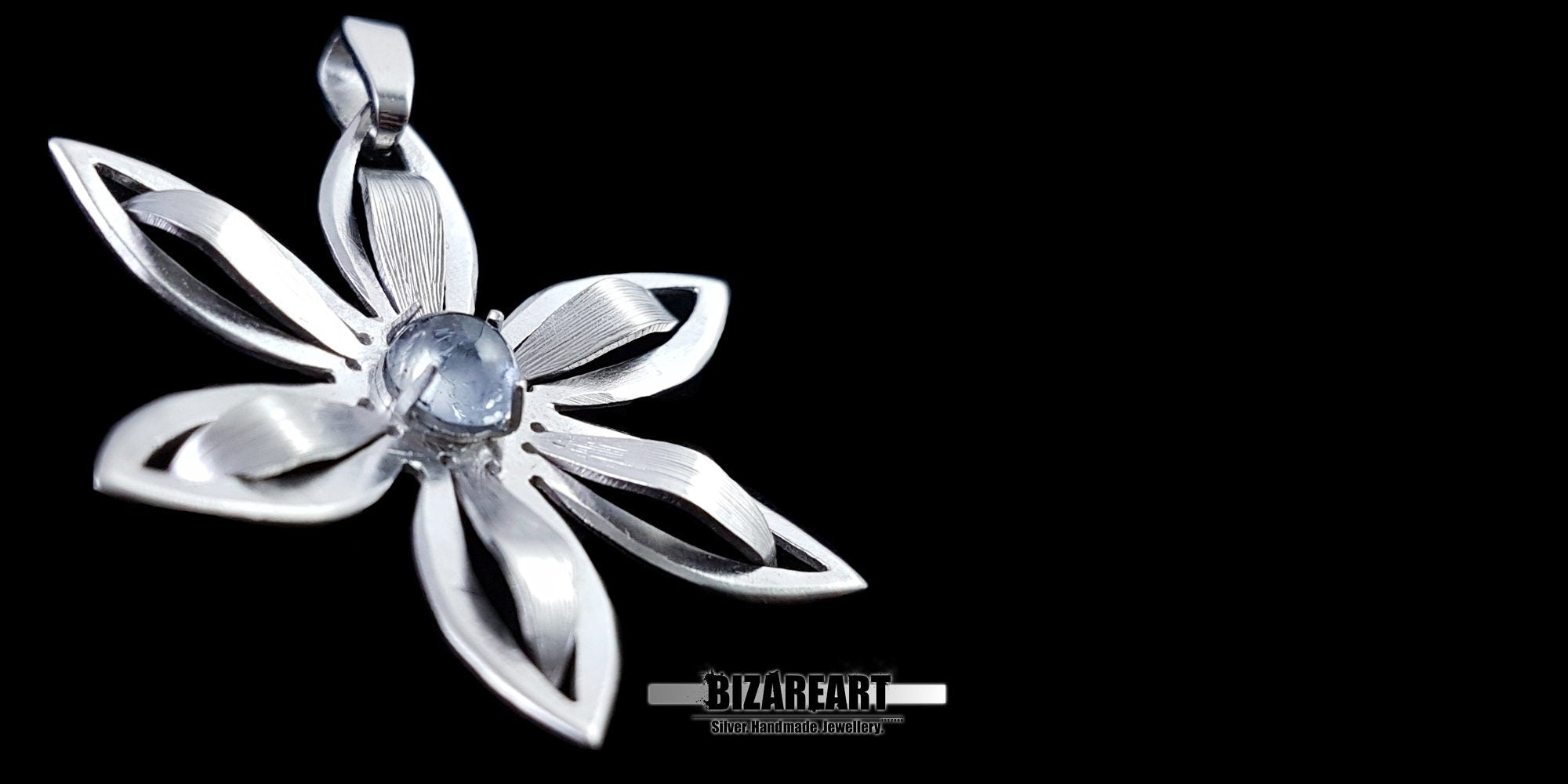 Handcrafted silver flower pendant held in hand to demonstrate the 4cm size and scale.
