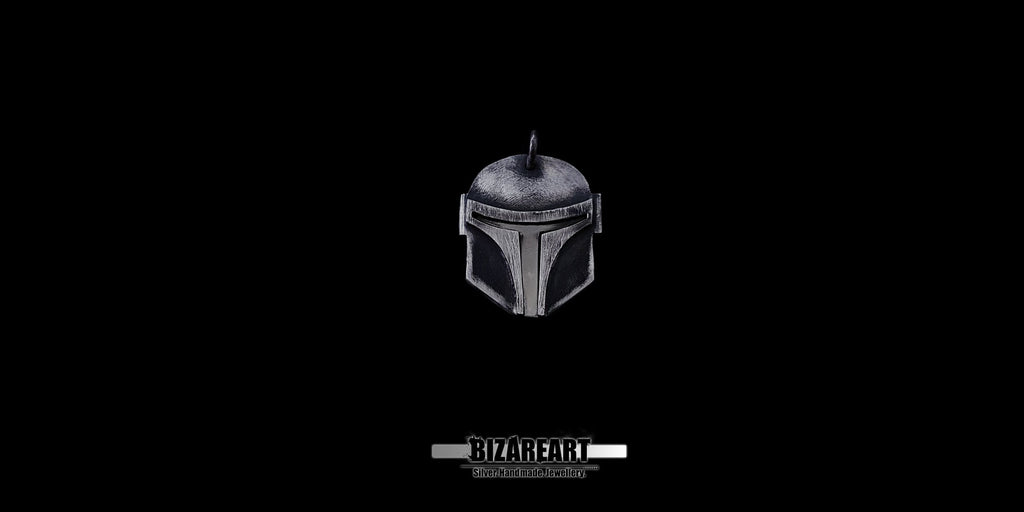 Front view of a handmade silver Mandalorian armor pendant featuring a detailed T-visor and battle-worn patina.