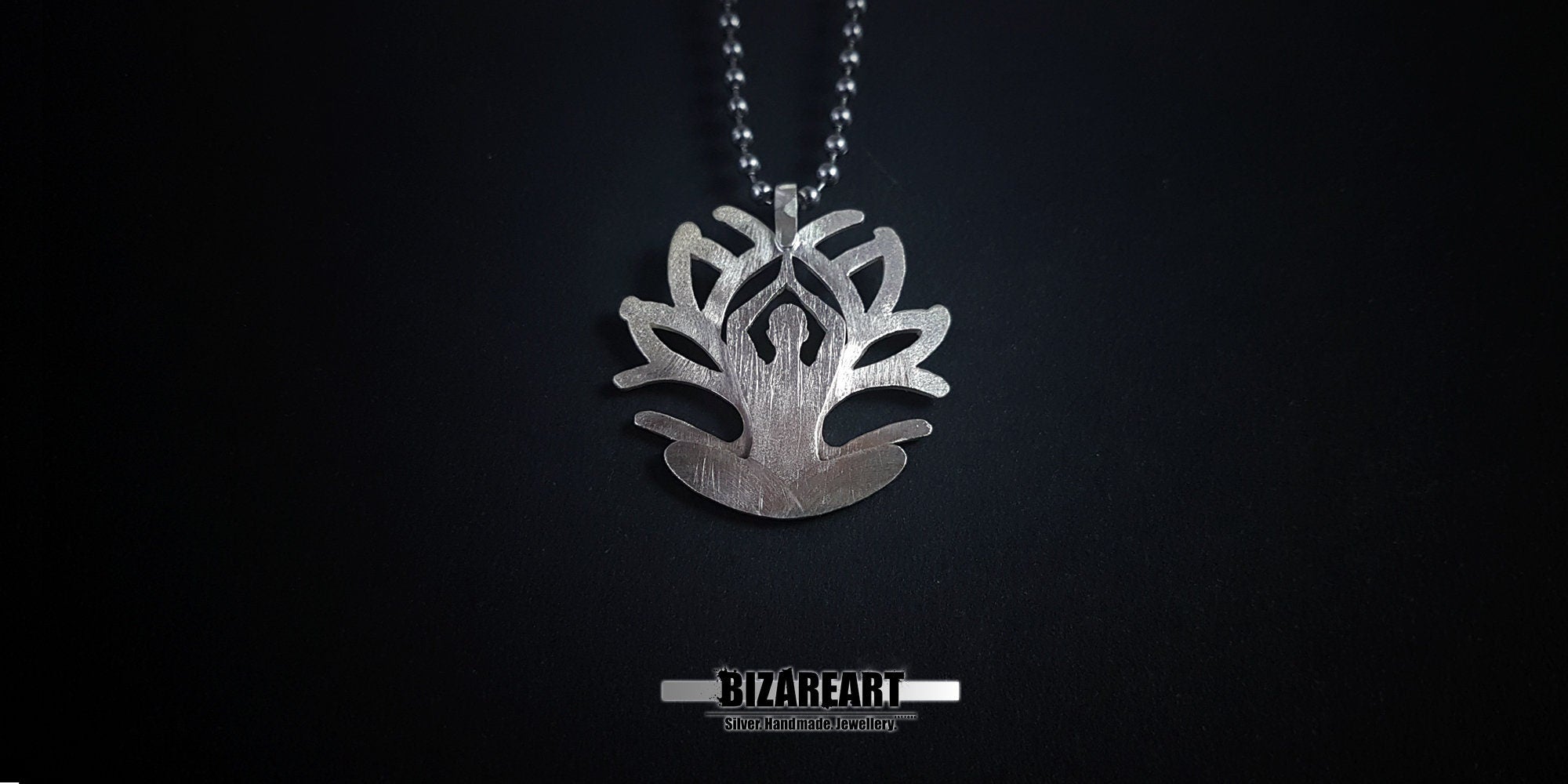 A wide-angle view of the pendant centered on a black backdrop, showcasing the balance of the lotus-inspired silhouette.