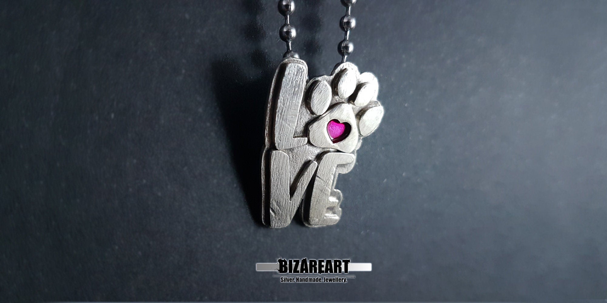 A close-up, slightly angled view of the pendant on a chain, emphasizing the multi-layered depth of the carved silver and the contrast between the matte and polished surfaces.