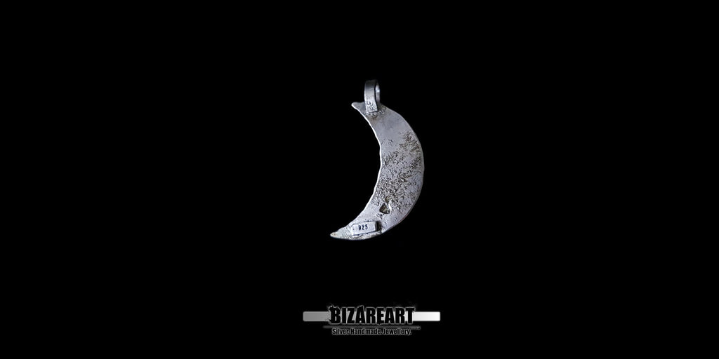 The back view of the silver crescent moon pendant against a black background, showing a raw, distressed metal texture and a visible 925 sterling silver hallmark stamp near the bottom tip.