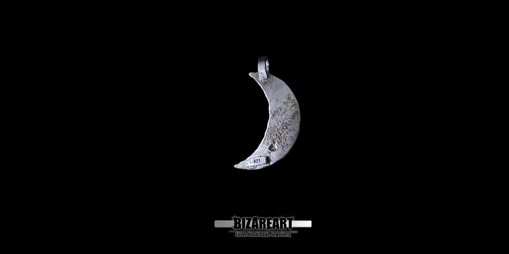 The back view of the silver crescent moon pendant against a black background, showing a raw, distressed metal texture and a visible 925 sterling silver hallmark stamp near the bottom tip.