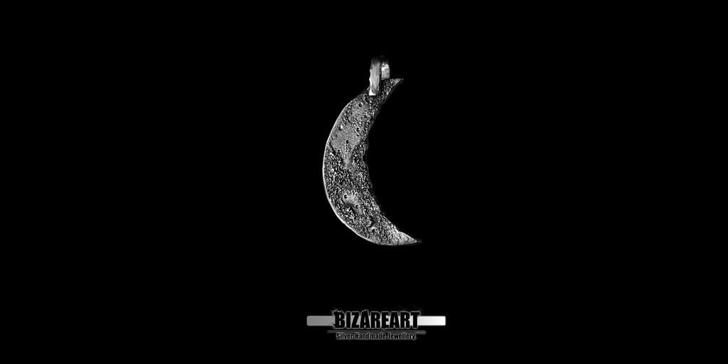 Side profile of the textured silver crescent moon pendant showing its curved depth.