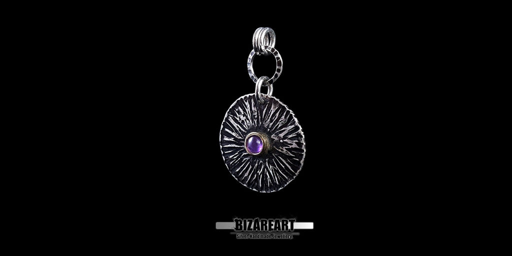 Angled side profile of the Bromo pendant highlighting the outward bend deformation and the hammered silver ring connector.