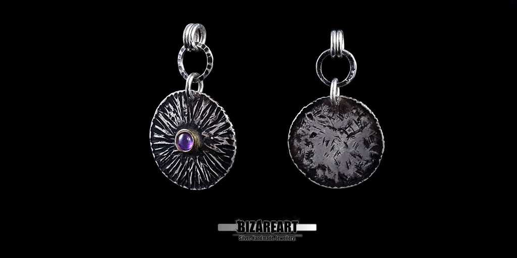 Two views of the Bromo Charm pendant side-by-side, showcasing the textured silver face with a purple amethyst gemstone and the rustic, oxidized reverse side.
