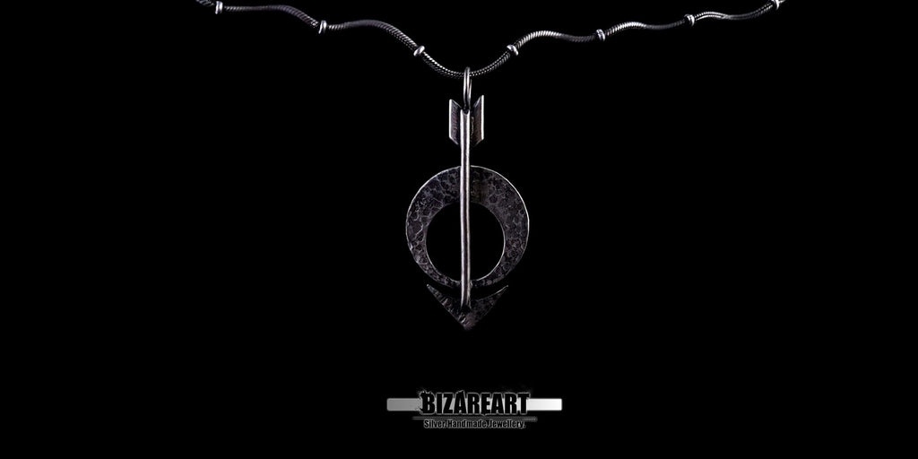Wide shot of the pendant attached to a fine silver chain against a dark backdrop.
