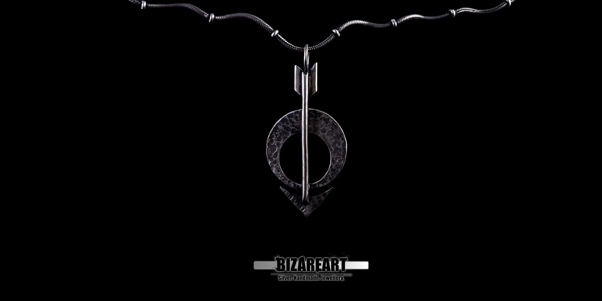 Wide shot of the pendant attached to a fine silver chain against a dark backdrop.