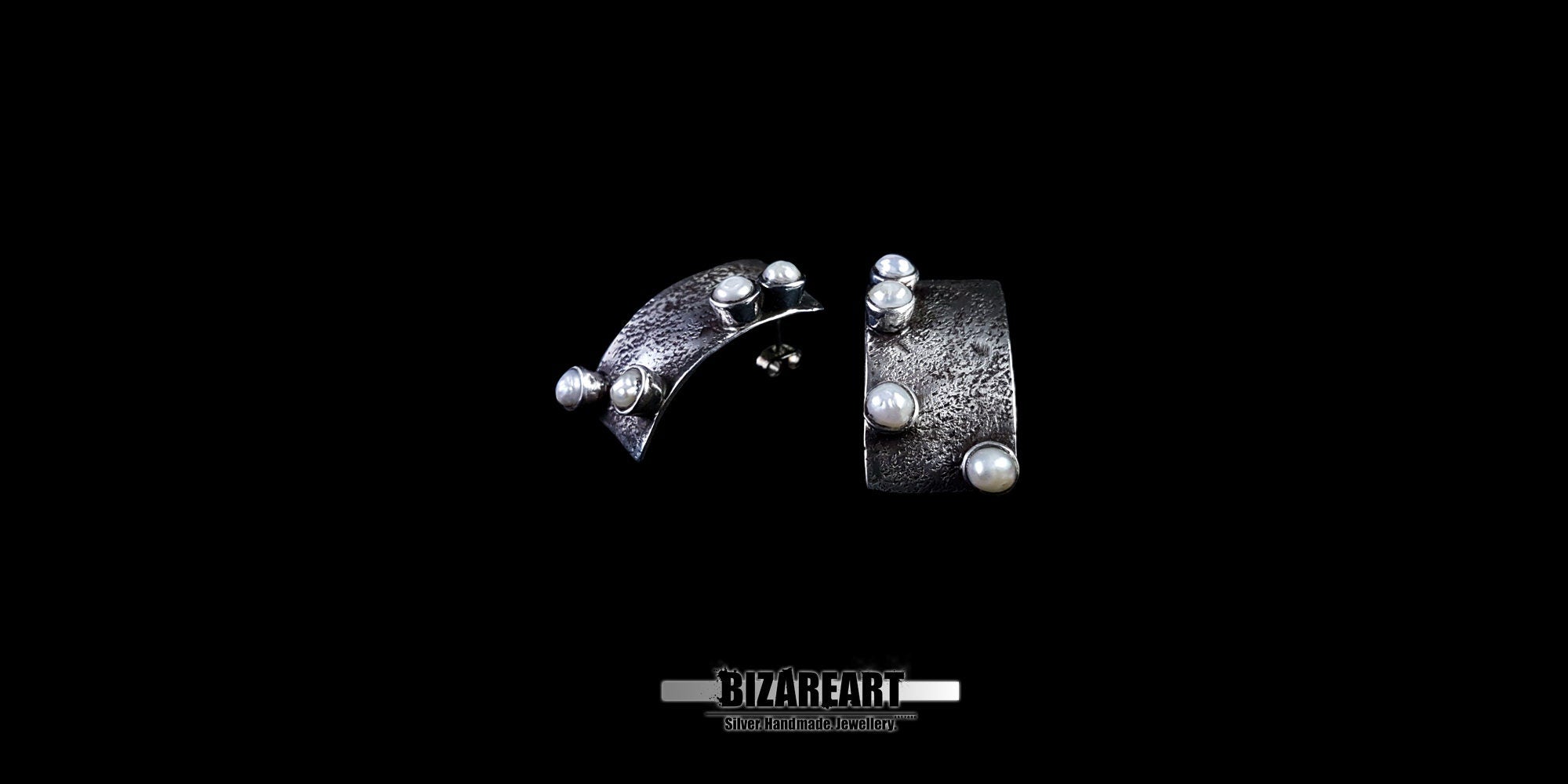 View of the subtle backward bend and sculptural profile of the oxidized sterling silver earrings.
