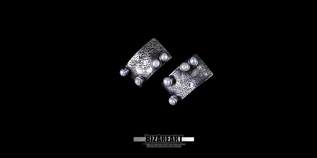 Top-down perspective showing the multiple silver bezels holding the white pearls in place.