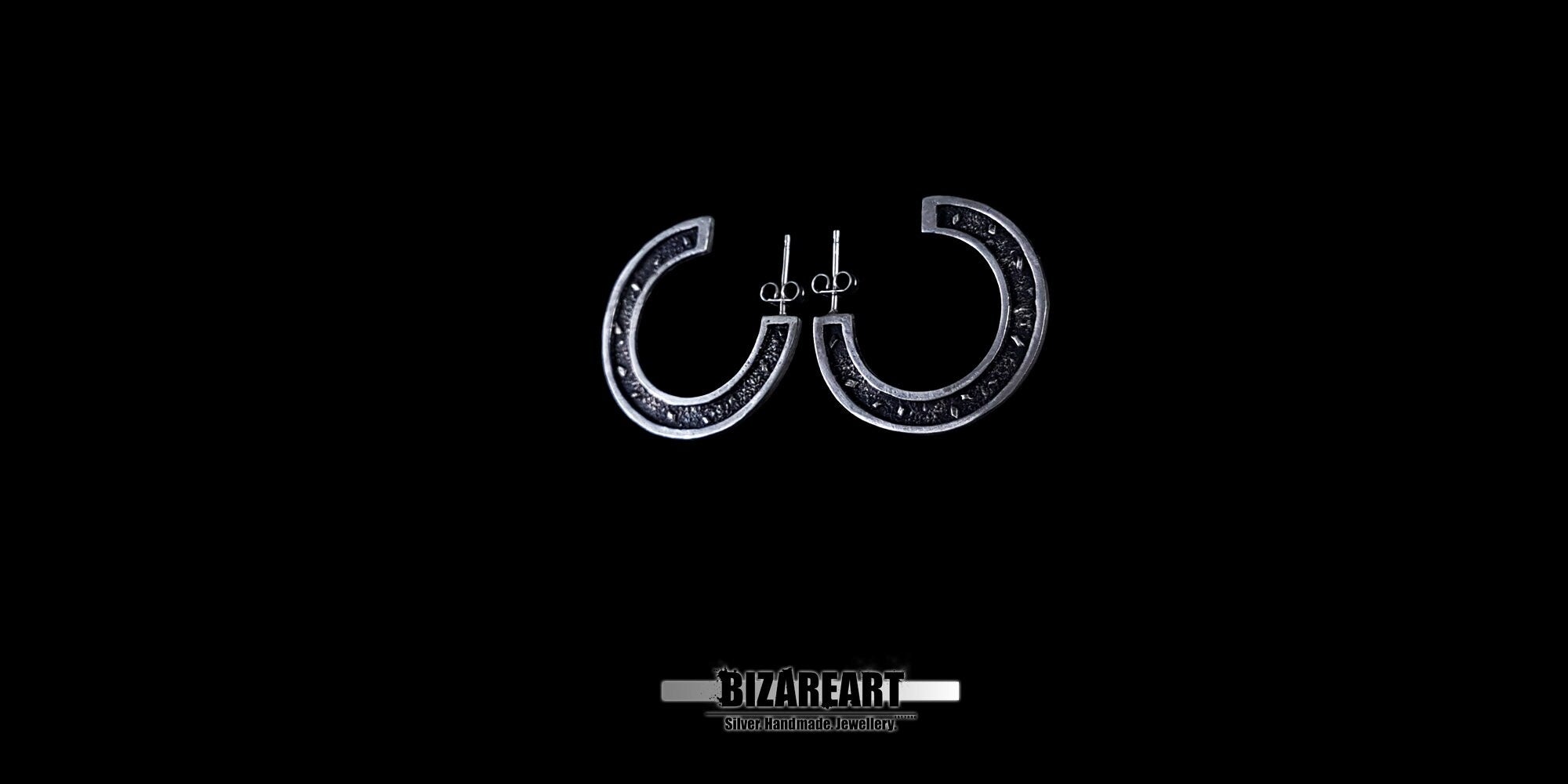 A centered view of the oxidized silver earrings, showcasing the secure stud pin backing and the dark, antique finish of the inner curves.