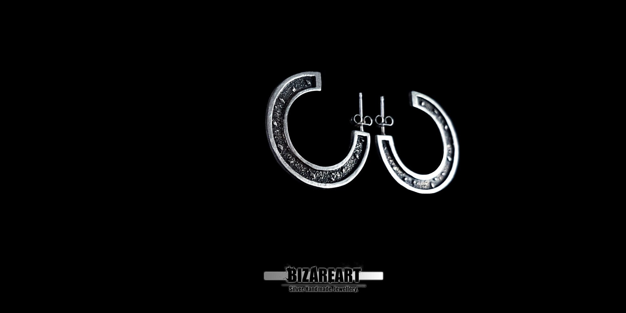 A front-facing studio shot of the silver granulation earrings, highlighting the symmetrical "C" shape and detailed ancient fusing technique.