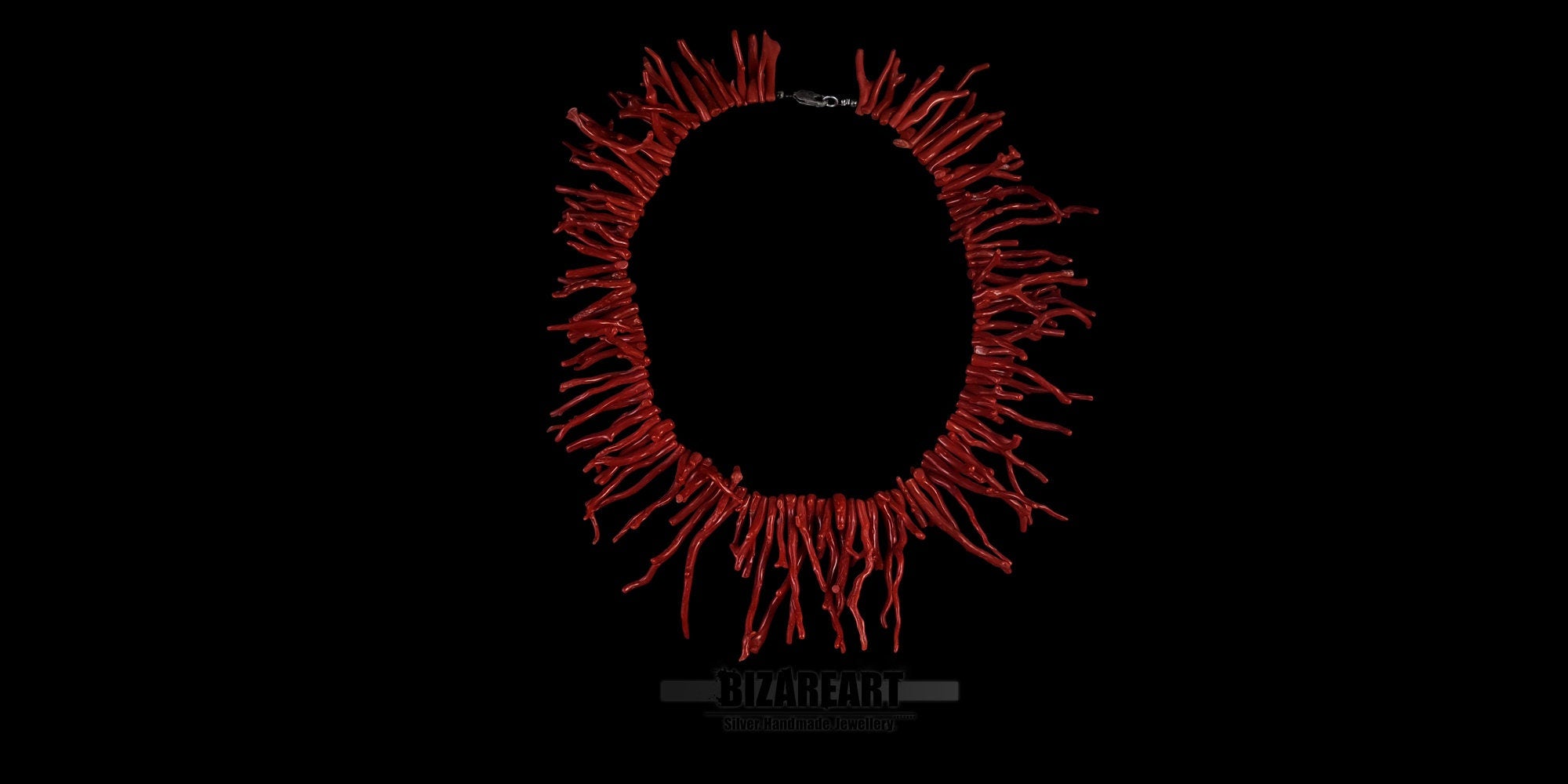 Handmade natural Mediterranean red coral branch statement necklace laid flat in a circular display against a solid black background.