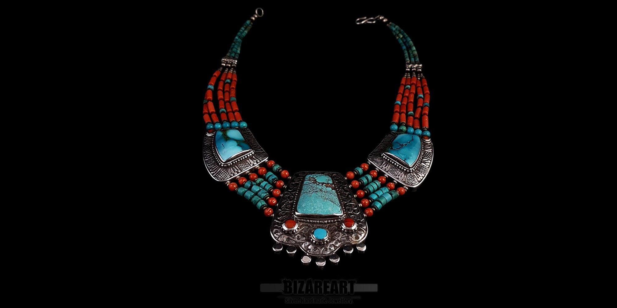 Symmetric front view of a vintage handmade Tibetan necklace featuring a large turquoise pendant, silver embellishments, and five strands of alternating red coral and turquoise beads.