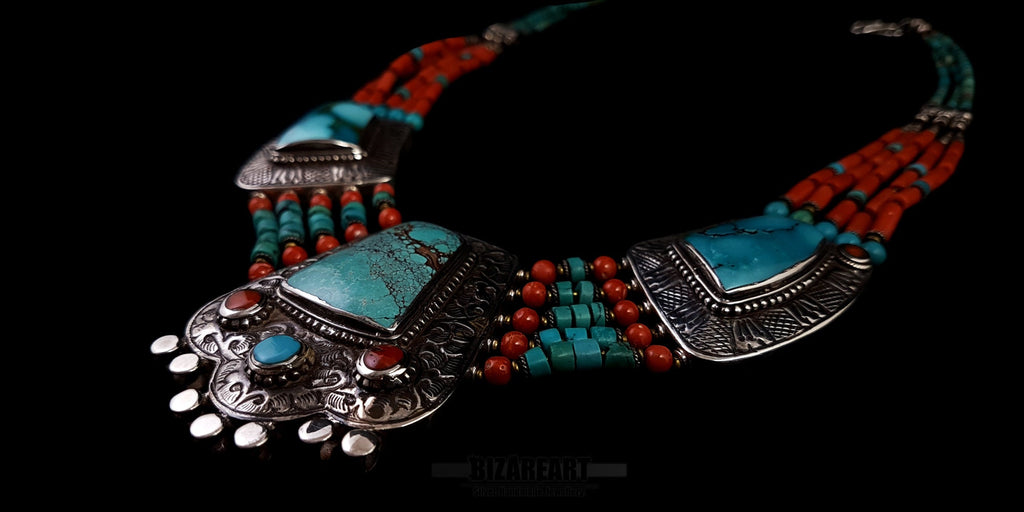Horizontal flat lay of the turquoise and coral statement necklace emphasizing the fine details of the silver side panels and graduated beadwork.