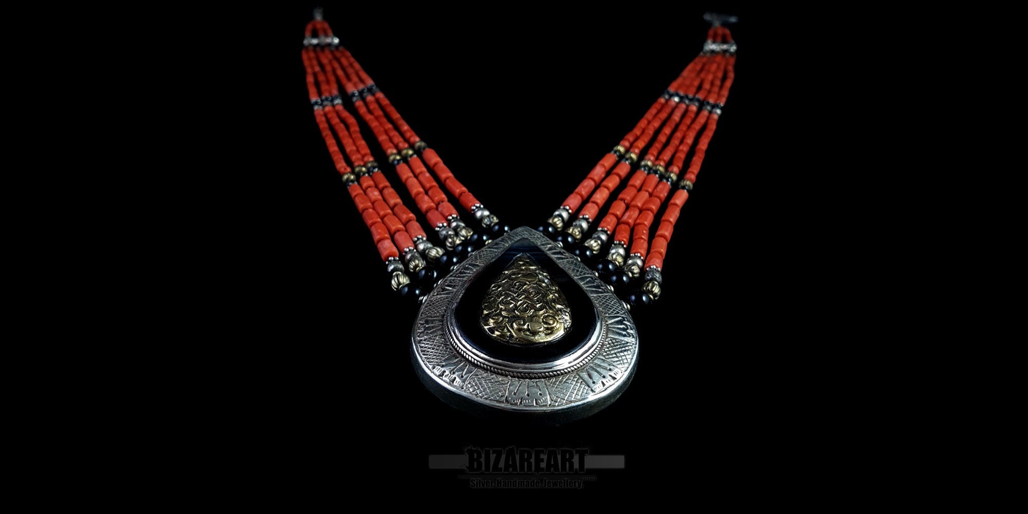 This hand-assembled masterpiece features six tiers of vibrant red coral and aged silver, anchored by a monumental teardrop pendant. 