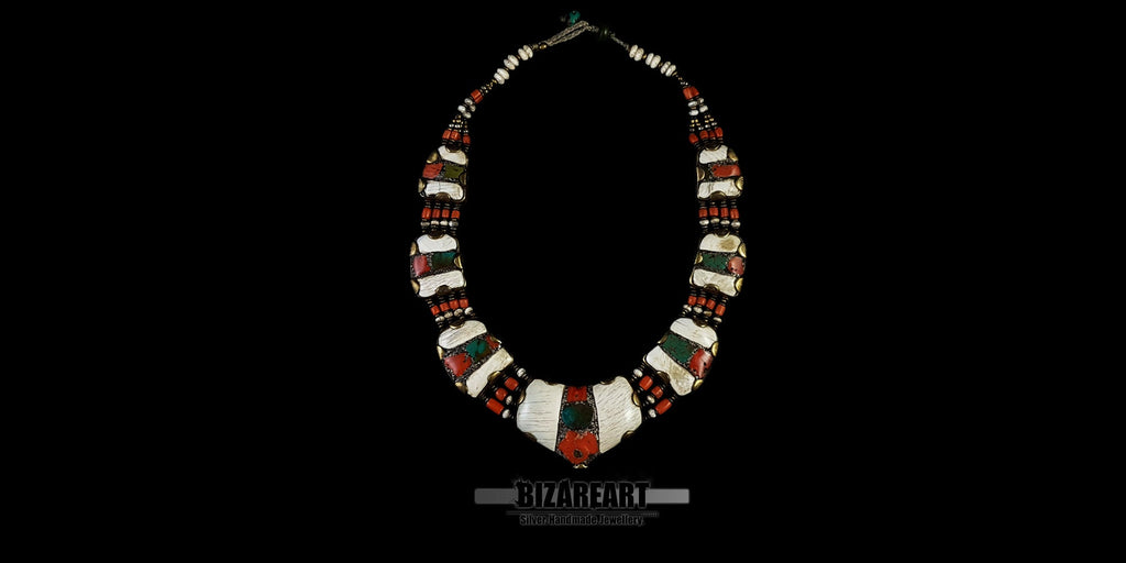 Full-length view of the handcrafted Nepalese necklace, showcasing the structured curvature, multi-strand coral beads, and the balance of contrasting gemstones.