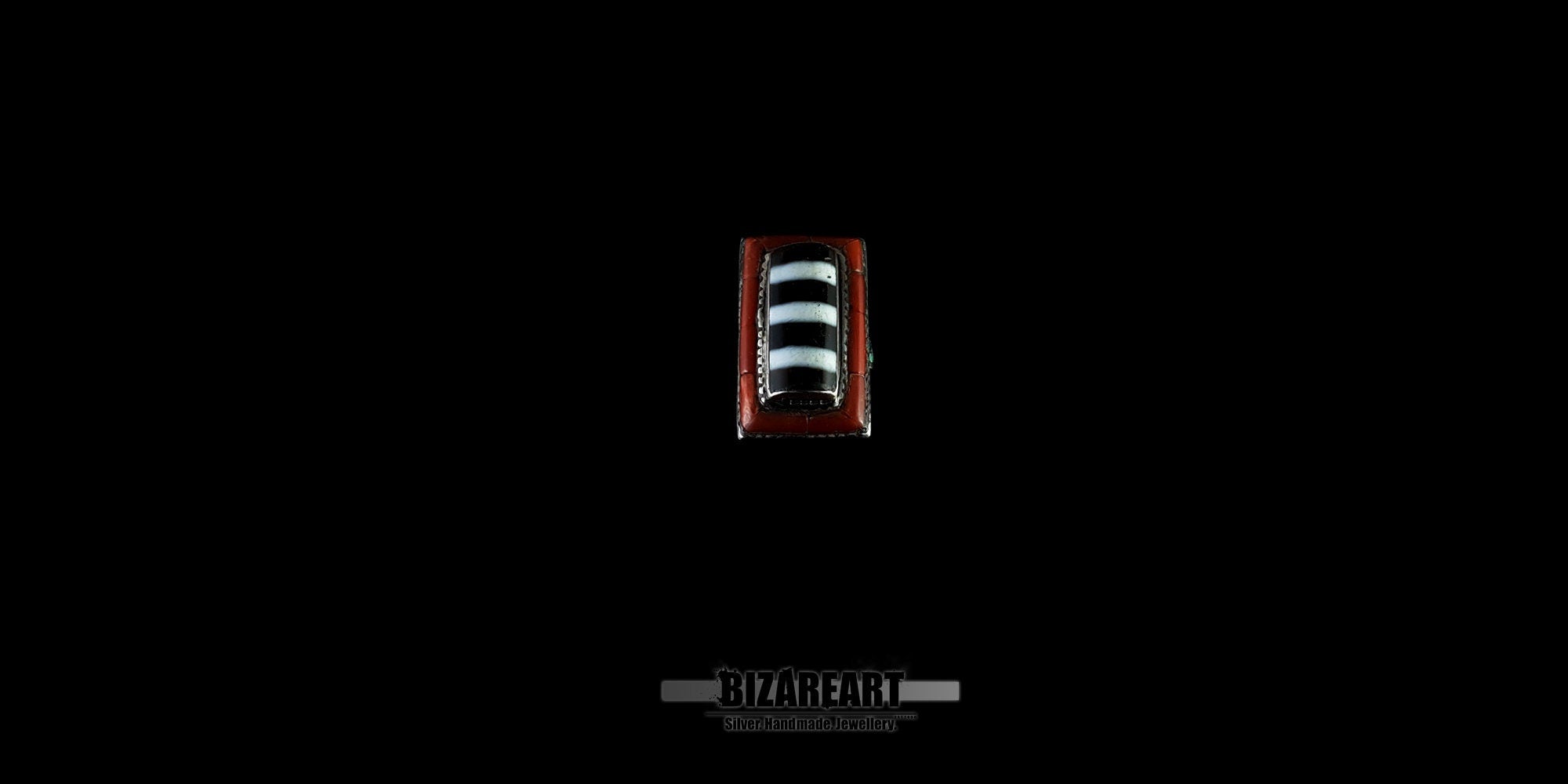 Direct top-down view of a vintage Tibetan ring, showcasing the symmetry of the rectangular striped agate and the surrounding red coral inlay border.