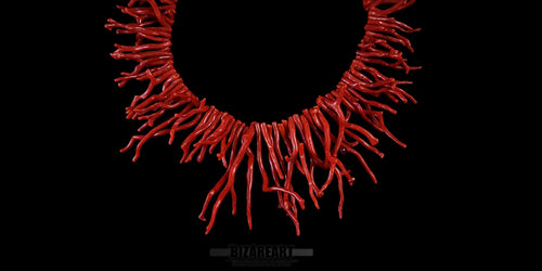 Close-up detail of polished red coral branches on a handmade sterling silver chain necklace