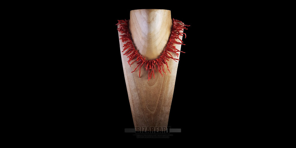 Premium Mediterranean red coral branch necklace displayed on a luxury wooden jewelry mannequin stand against a black background.