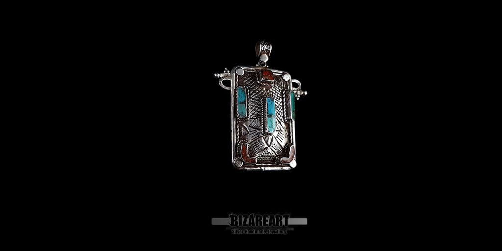Side view of handmade Tibeto-Nepalese silver pendant showing raised bezels and detailed engravings.