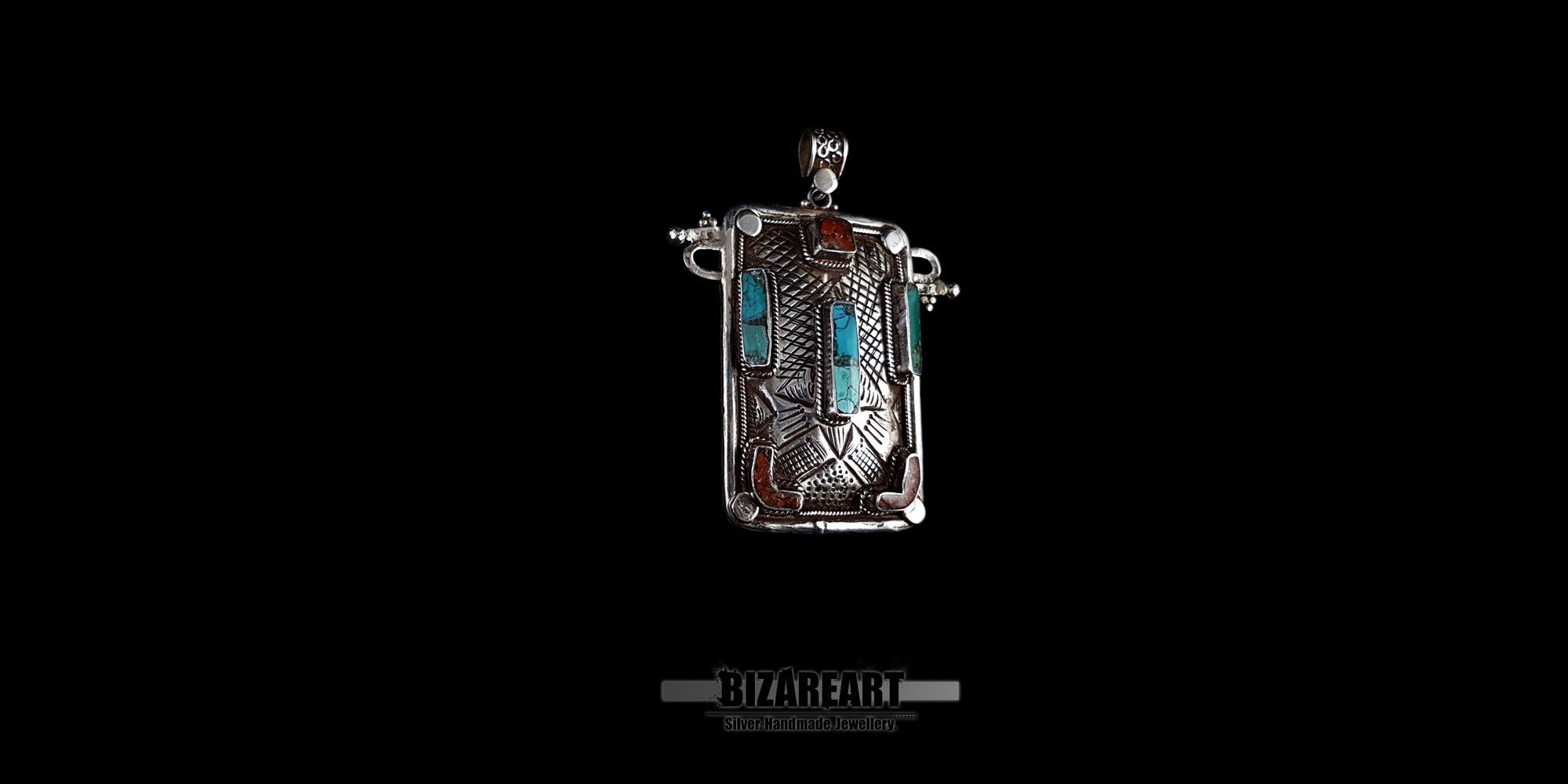 Side view of handmade Tibeto-Nepalese silver pendant showing raised bezels and detailed engravings.