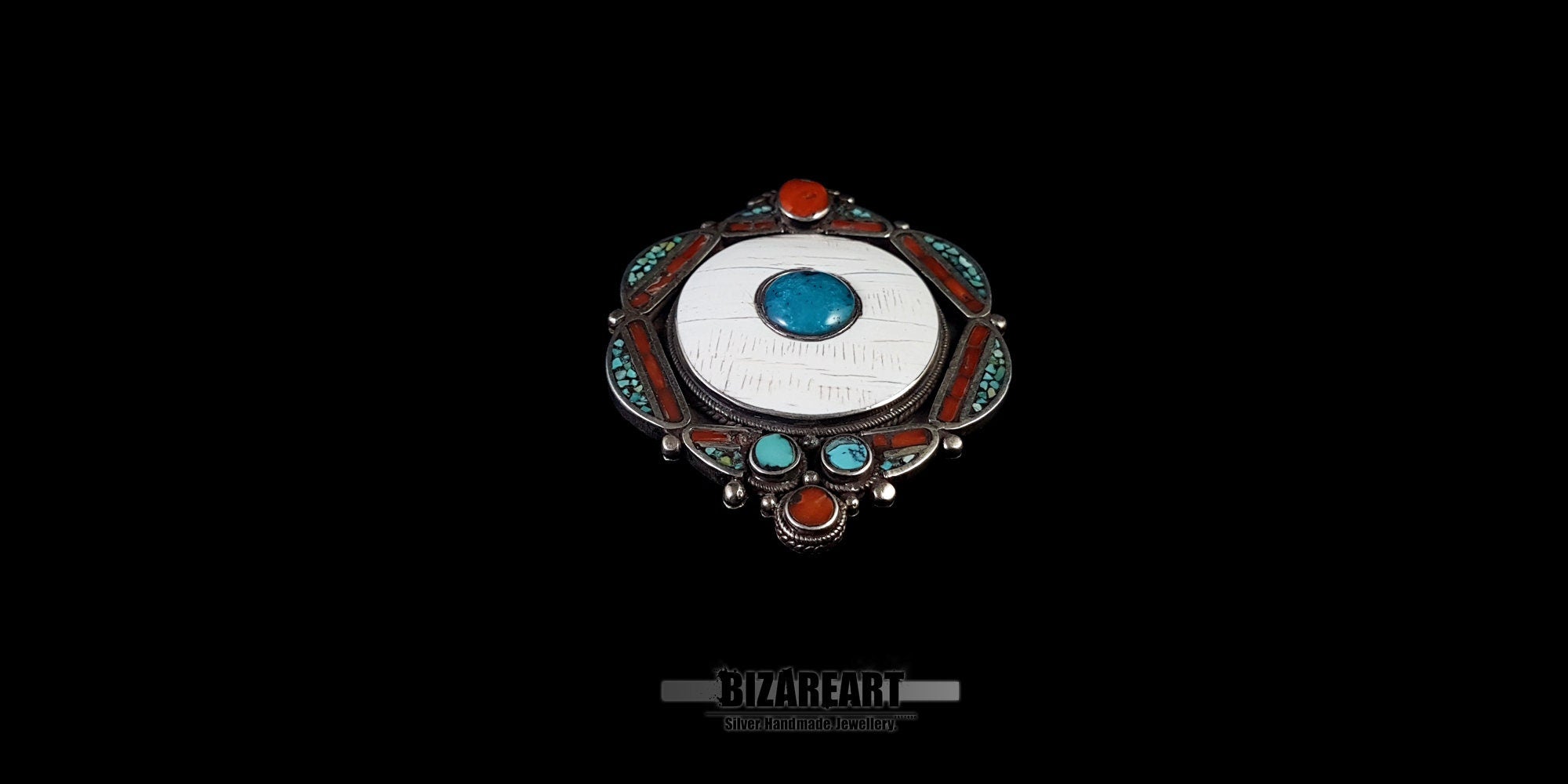 Handcrafted Himalayan statement pendant with red coral and turquoise mosaic bezels on a black backdrop.