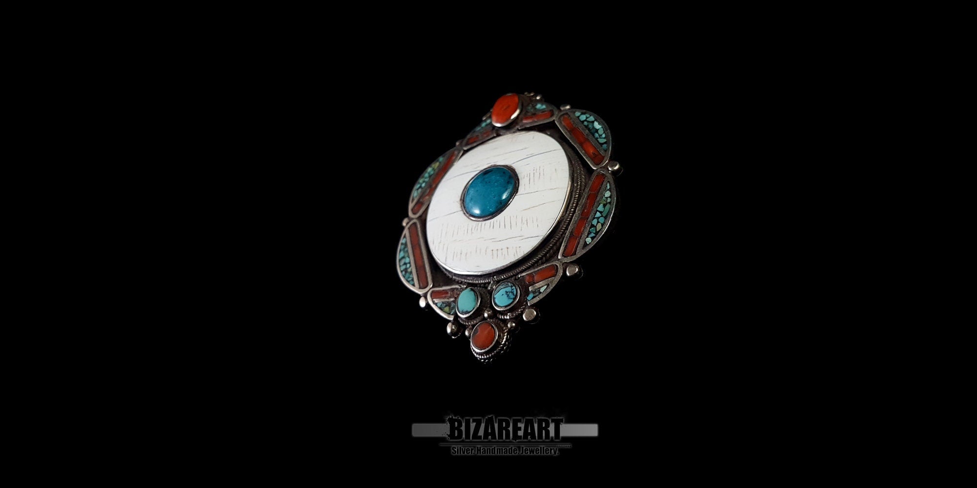 Detailed close-up of the sacred running border pattern and colorful gemstone setting on the handcrafted Tibetan pendant.