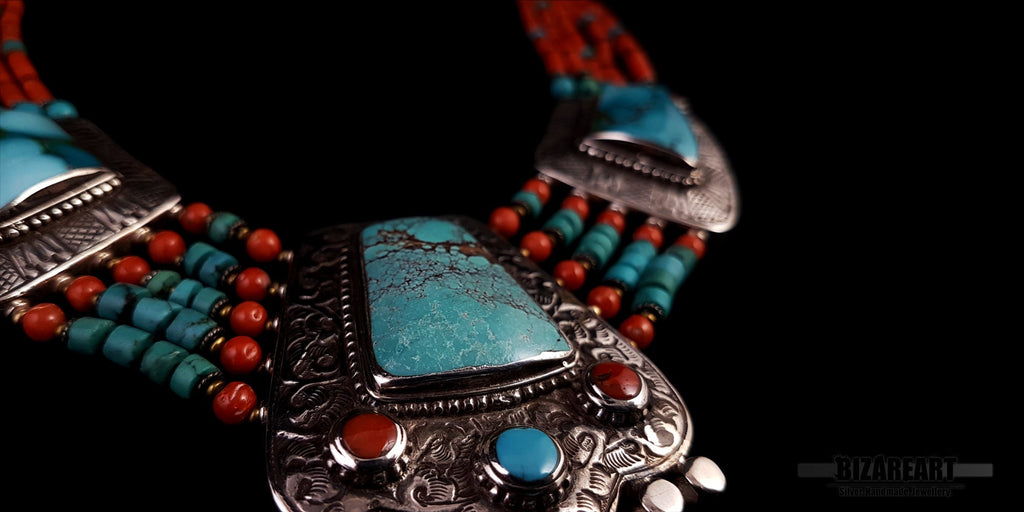 A close-up shot of the artisan necklace being held to demonstrate the substantial scale, size, and craftsmanship of the main silver pendant.
